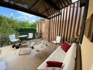 - un salon avec un canapé et des chaises sur une terrasse dans l'établissement Lodge Villa Maria, à Teolo