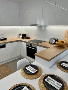 a kitchen with white cabinets and black plates on a table at Rodanthi 4 Seasons Unique House in Tympáki