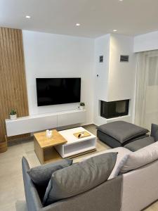 uma sala de estar com um sofá e uma televisão de ecrã plano em Rodanthi 4 Seasons Unique House em Tympáki