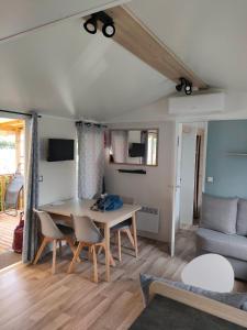 a living room with a table and chairs and a couch at Au lac des rêves in Lattes