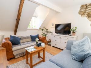 a living room with a couch and a tv at Spring Cottage in Stroud