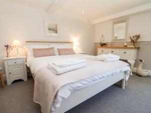 a bedroom with two beds and two tables and a mirror at Spring Cottage in Stroud