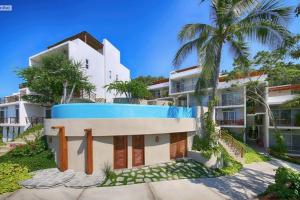 an exterior view of a building with a palm tree at Vista al Mar - Monterosa in Sayulita