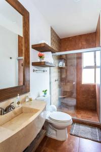 a bathroom with a toilet and a shower and a sink at Vista al Mar - Monterosa in Sayulita