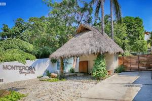 a small house with a straw roof at Vista al Mar - Monterosa in Sayulita