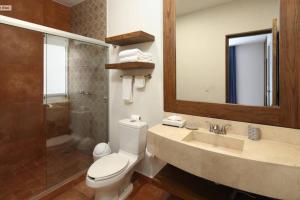 a bathroom with a toilet and a sink and a mirror at Vista al Mar - Monterosa in Sayulita +10 photos