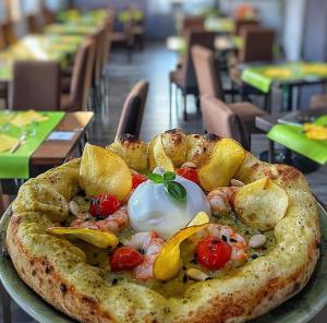 een pizza zittend op een bord op een tafel bij Hotel Palladium in Monastir