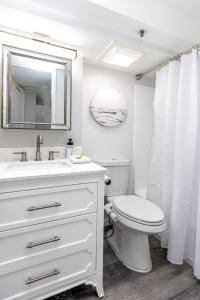 La salle de bains est pourvue de toilettes, d'un lavabo et d'un miroir. dans l'établissement Waikiki Gem, Beautifully Upgraded King Studio!, à Honolulu