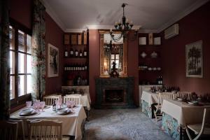 comedor con mesas blancas y chimenea en Villa Tela & Vino, en Montilla