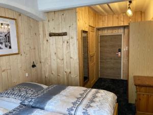 1 dormitorio con 1 cama y pared de madera en Zur Baumwolle Family Suites en Núremberg