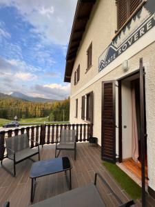 a patio with chairs and tables on a building at Monterovere in Albergo Monte Rovere