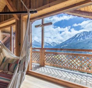 a hammock in a cabin with a view of mountains at Chalet Le Perray Alpine Lodge in Abondance