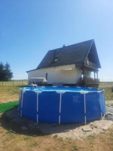 a hot tub in front of a house at Mazurska Sielanka in Orzysz
