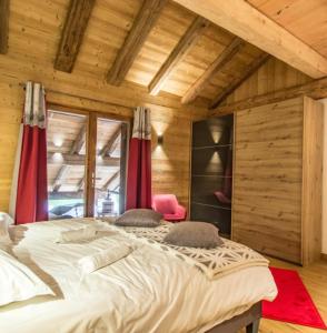 a large bed in a room with wooden walls at Chalet Le Perray Alpine Lodge in Abondance