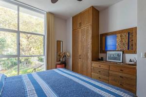 a bedroom with a bed and a large window at Skyhouse in Sayulita