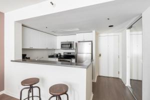 a kitchen with white cabinets and two bar stools at South Beach 1br w pool gym lounge nr dining SFO-1405 in San Francisco