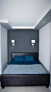 a bedroom with a bed with two lights on it at Esplanada aparments in Sumy