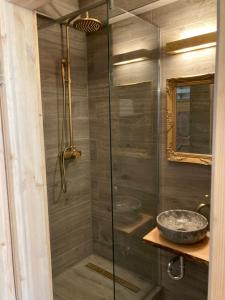 a bathroom with a glass shower with a sink at Zur Baumwolle Family Suites in Nuremberg