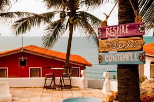 a resort with a palm tree and a table and chairs at Lua Morena in Aracati