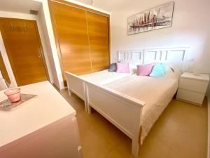 una camera da letto con un letto con cuscini rosa e blu di ENJOY Mar Menor a Torre-Pacheco