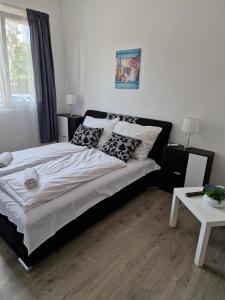 1 dormitorio con cama con almohadas y mesa en Villa Gabino, en Balatonberény