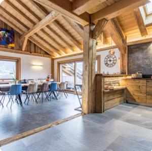 a kitchen and dining room with wooden ceilings and tables at Chalet Le Perray Alpine Lodge in Abondance