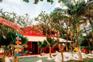 a resort with palm trees and a red building at Lua Morena in Aracati
