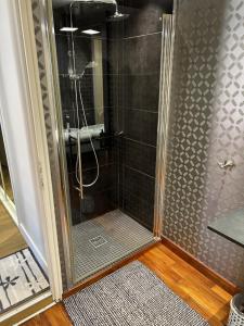 a shower with a glass door in a bathroom at Le Jardin des Anges in Saint-Jean-dʼAngély