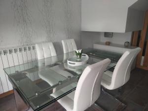 - une table en verre et des chaises blanches dans la chambre dans l'établissement Adosado en Cirueña con Chimenea, à Cirueña