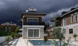a house with a swimming pool in front of a building at Amore Hotel Teki̇rova in Tekirova