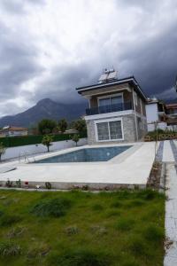a house with a swimming pool in front of a house at Amore Hotel Teki̇rova in Tekirova