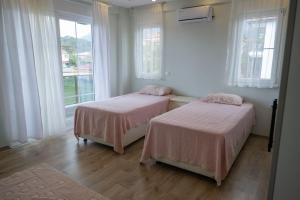 two beds in a room with two windows at Amore Hotel Teki̇rova in Tekirova