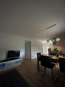 sala de estar con mesa de comedor y TV en Apartments Tome, en Liubliana