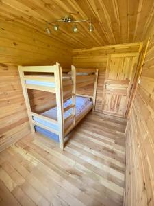 a room with two bunk beds in a wooden cabin at Sosenkowe Zacisze in Ciche