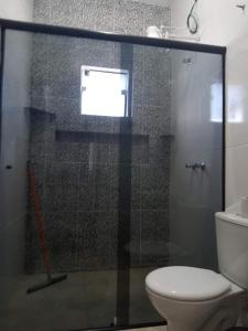 a bathroom with a shower with a toilet and a window at CASA TOCA FURADA in São Thomé das Letras