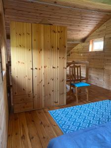 a bedroom with a bed and a chair in a cabin at Sosenkowe Zacisze in Ciche