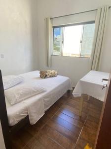 a room with two beds and a window at CASA TOCA FURADA in São Thomé das Letras