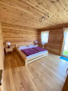 a bedroom with a bed in a wooden room at Sosenkowe Zacisze in Ciche