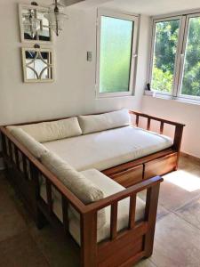 - un canapé en bois dans une chambre avec 2 fenêtres dans l'établissement Amazing apartment, Juan Dolio, El Bonio II- 2B, à Juan Dolio