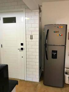 Cette chambre dispose d'un réfrigérateur en argent et d'un mur en briques. dans l'établissement Amazing apartment, Juan Dolio, El Bonio II- 2B, à Juan Dolio