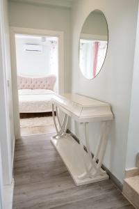 a white dressing table with a mirror and a bed at Amore Hotel Teki̇rova in Tekirova