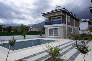 a villa with a swimming pool and a house at Amore Hotel Teki̇rova in Tekirova