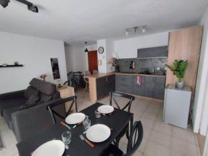 a kitchen and a living room with a table and chairs at Appartement 46 in Doussard