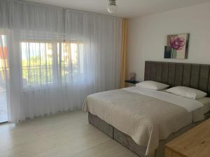um quarto com uma cama e uma grande janela em The48 em Zadar