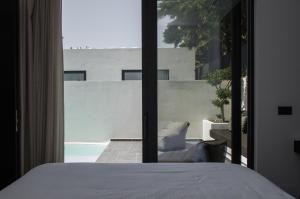 a bedroom with a bed and a view of a balcony at Hygge Suites in Hersonissos