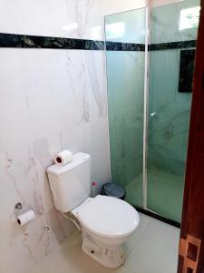 uma casa de banho com um WC e uma cabina de duche em vidro. em Hospedaje MorroSP em Morro de São Paulo