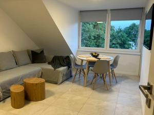 a living room with a couch and a table with chairs at Velobaltica apartmenty in Wisełka