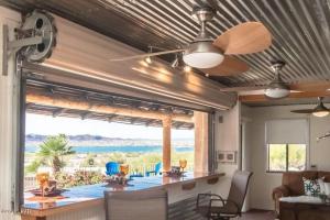 een woonkamer met een plafondventilator en een groot raam bij Villa La Isla PANORAMIC VIEWS, Outdoor Kitchen, sleeps 16 in Lake Havasu City