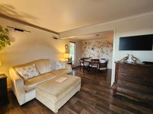 a living room with a couch and a table at Blue Bell Cottage. Serene luxury farmstead in Lower Moutere