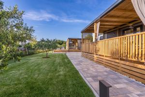 a patio of a house with a yard at Giardino Sukošan - new mobile houses in olive garden in Sukošan